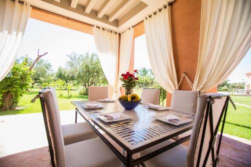 a dining room with a table and chairs at Villa Koutoubia, jardin luxuriant, piscine et spa in Marrakech