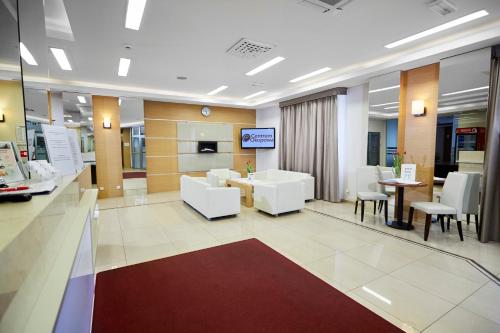 a hospital lobby with white chairs and a table at Centrum Okopowa 55 in Warsaw