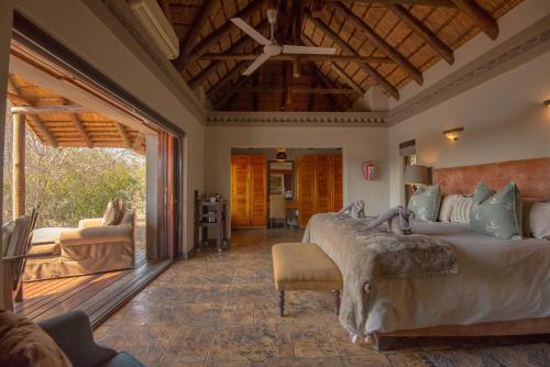 a bedroom with a large bed and a living room at Waterbuck Game Lodge Thornybush Nature Reserve in Thornybush Game Reserve