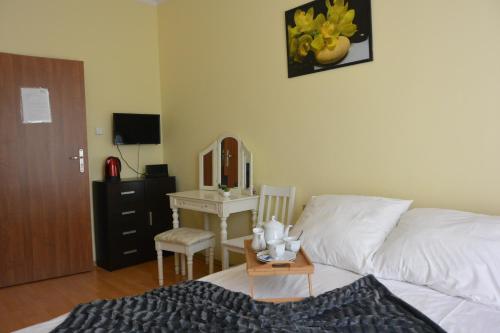 1 dormitorio con cama, mesa y espejo en Hostel DV Morski - z prywatnymi łazienkami, en Gdynia