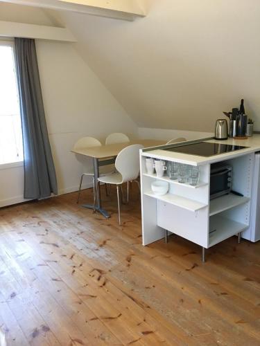 a kitchen with a table and a table and chairs at Ebogaard in Hillerød