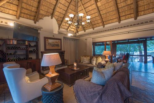 a living room with couches and a chandelier at Waterbuck Game Lodge Thornybush Nature Reserve in Thornybush Game Reserve