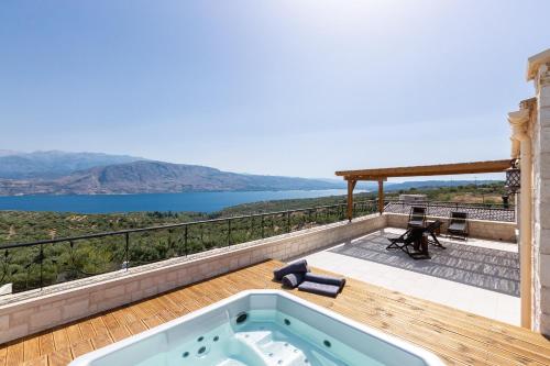 a hot tub on a deck with a view of the water at Elements Villa in Galangádhos
