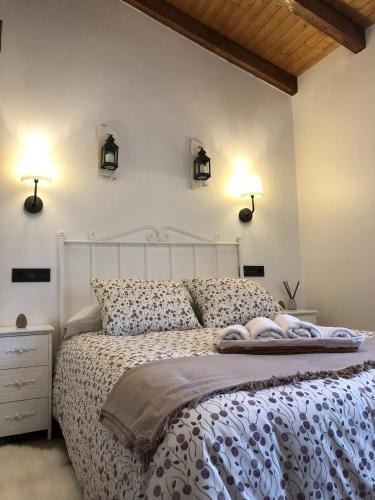 a bedroom with a white bed and two lights on the wall at Las vistas in Cornellana