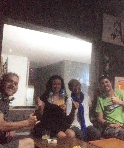 a group of people sitting on a table with wine glasses at Apollo Hostel in Lovina