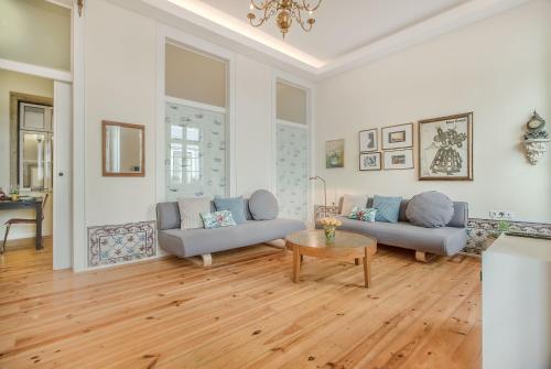 een woonkamer met 2 banken en een tafel bij Correeiros Downtown - Historic Lisbon Apartment in Lissabon