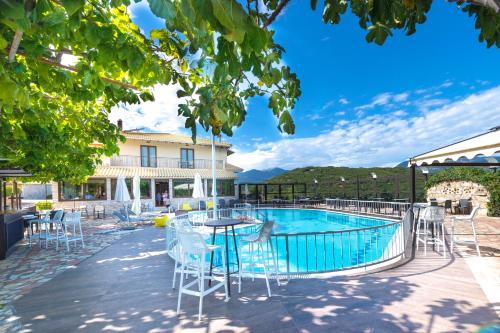 a patio with a table and chairs next to a pool at Thermios Apollon in Thermo