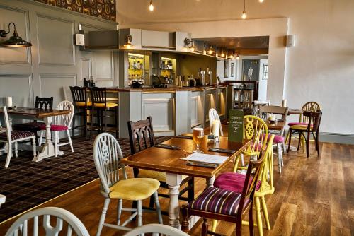 グレンジ・オーバー・サンズにあるThe Commodore Innのテーブルと椅子のあるレストラン、キッチンが備わります。