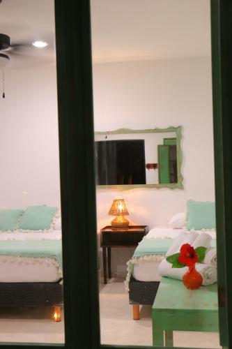 トゥルムにあるPunta Piedra Beach Posadaのベッドルーム1室(ベッド2台、鏡付きテーブル付)