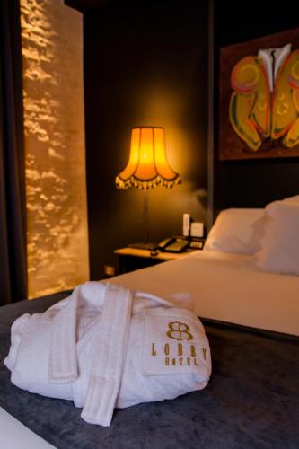 a hotel room with a white towel on a bed at Hotel Lobby in Seville