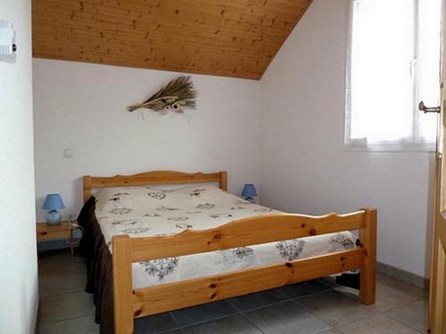 a bedroom with a wooden bed in a room at Gite les Myosotis in Saint-Jean-Saint-Nicolas