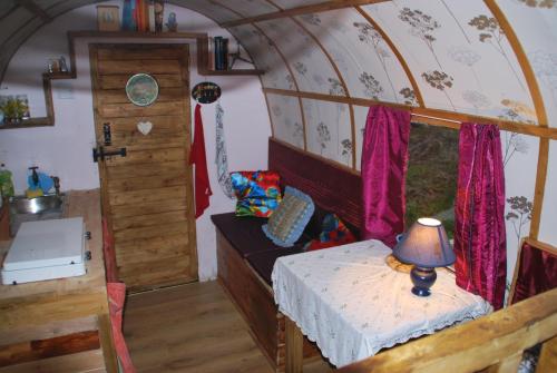 una piccola camera con tavolo e lampada in treno di The Wonderly Wagon a Fintown