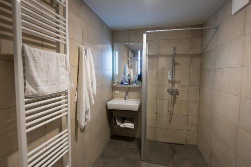 uma casa de banho com um lavatório e um chuveiro em Seegasthof Breineder - Familien & Seminarhotel em Mönichwald