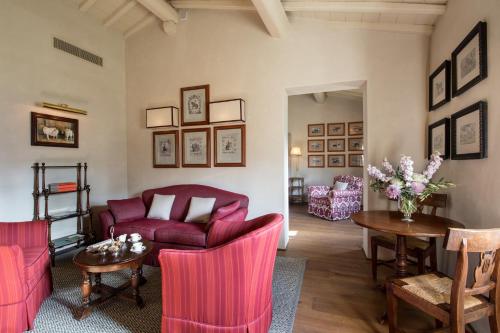 a living room with a red couch and a table at Il Borro Relais & Châteaux in San Giustino Valdarno