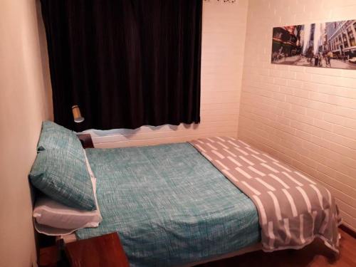 a small bedroom with a bed with a window at Dianella · Affordable & comfortable close to the city & shops in Perth