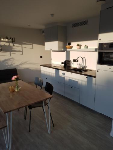 a kitchen with a wooden table and a dining room at Homey - Kortrijk in Kortrijk
