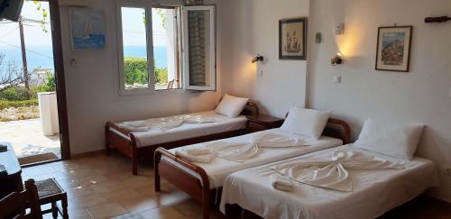 a room with two beds and a window at Studios Marfo in Batsi