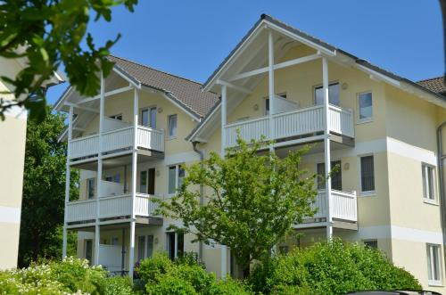 un immeuble d'appartements avec balcon et arbres dans l'établissement Wohnpark Stadt Hamburg in Binz - WG 54, à Binz