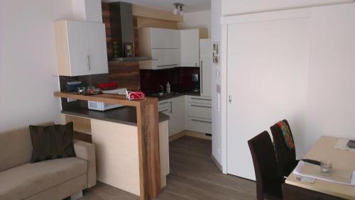 eine kleine Küche mit einem Tisch und einem Sofa in einem Zimmer in der Unterkunft Ferienwohnung Huber in Seeboden