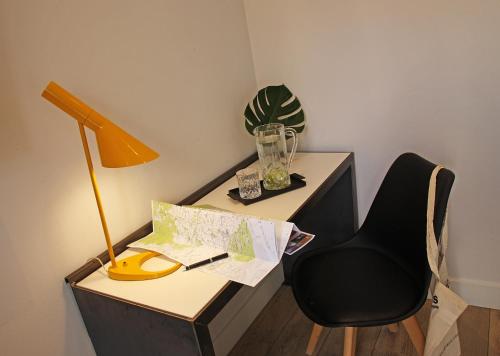 
a desk with a chair and a lamp at Chic & Basic Lemon Boutique Hotel in Barcelona
