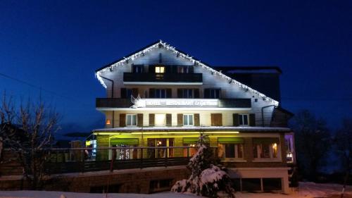 a large building with lights on it at night at Hotel Restaurant LE YETI in Les Rousses