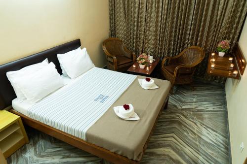 een hotelkamer met een bed met twee borden eten erop bij Hotel Victoriyah in Thanjāvūr