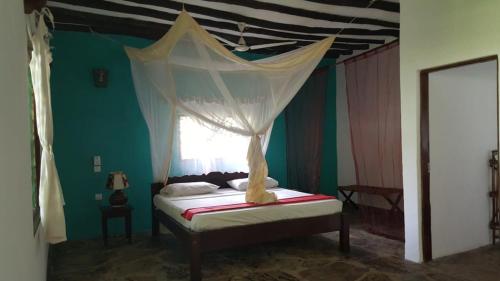 a bedroom with a canopy bed with a window at Eco Villas Watamu in Watamu