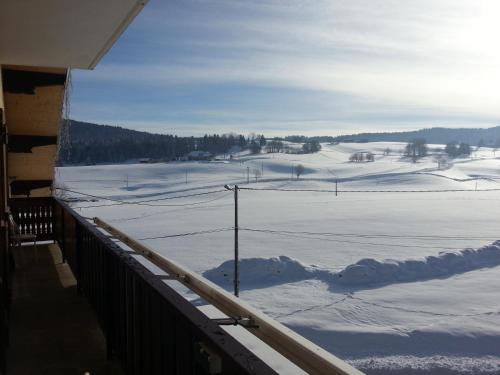a view of a snow covered field from a balcony at Hotel Restaurant LE YETI in Les Rousses