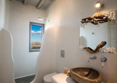 a bathroom with a wooden sink and a toilet at Amallini Suites Mykonos in Super Paradise Beach