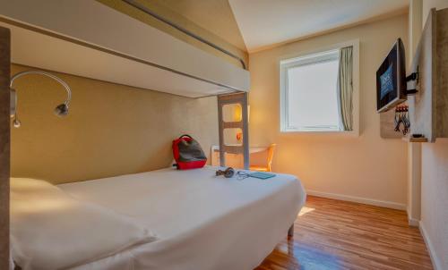 a bedroom with a bed with a red bag on it at ibis budget SP Centro Sao Joao in Sao Paulo