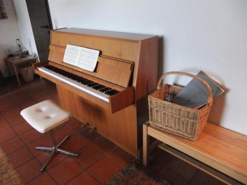 a piano with a chair and a basket next to it at Ferienhaus Ammermann in Lissendorf