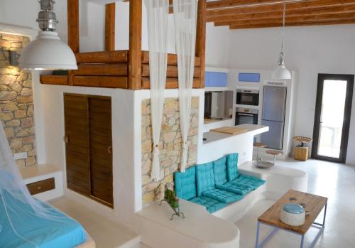 a living room with a blue couch and a table at STUDIOSWORX Apartments in Ios Chora