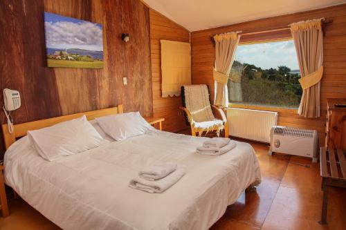 um quarto com uma cama com duas toalhas em Hotel Faros del Sur em Ancud