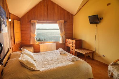 a bedroom with a bed and a window at Hotel Faros del Sur in Ancud