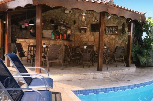 a restaurant with a table and chairs next to a pool at Pousada Do Forte in Paraty