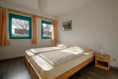 ビンツにあるFerienwohnung-Meeresbriseのベッドルーム1室(ベッド2台、窓2つ付)