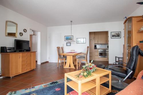ein Wohnzimmer mit einem Tisch und einer Küche in der Unterkunft Apartmenthaus Strelasund Whg  11 in Binz
