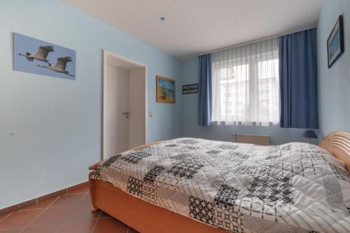 Schlafzimmer mit einem Bett und einem Fenster in der Unterkunft Apartmenthaus Strelasund Whg  11 in Binz