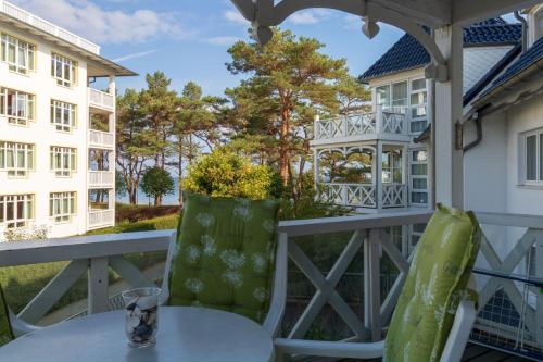 eine Terrasse mit einem Tisch und Stühlen sowie ein Gebäude in der Unterkunft Apartmenthaus Strelasund Whg  11 in Binz
