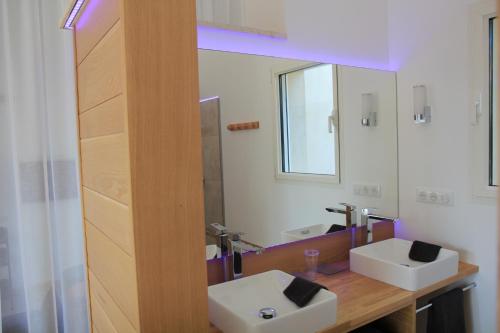 a bathroom with two sinks and a mirror at Le Fournil en Provence in Caseneuve
