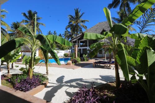 a resort with a pool and palm trees at Kiganja in Matemwe