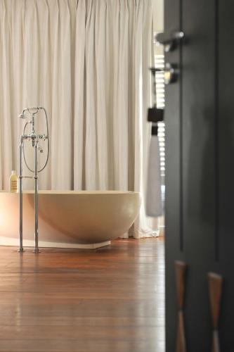 a white bath tub sitting in front of a window at La Maison d'Aix 1785 - Hôtel Particulier & Spa in Aix-en-Provence