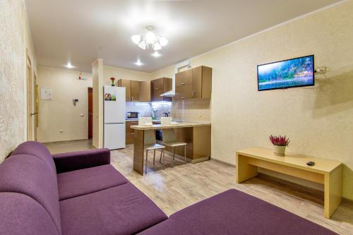ウファにあるSutkiUfa Рихарда Зорге 67/2の紫色のソファ付きのリビングルーム、キッチンが備わります。