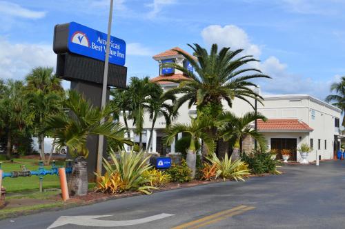 a street sign in front of a building with palm trees at Americas Best Value Inn Fort Myers in Fort Myers