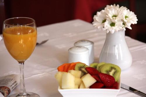 a plate of fruit next to a glass of orange juice at Hotel Principe Paz in Santa Cruz de Tenerife