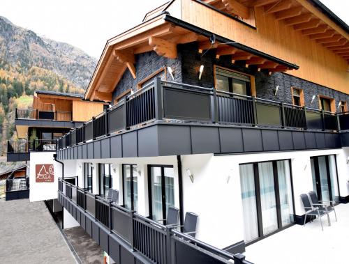 a building with a balcony with chairs on it at A CASA Rubin Chalet & Studio Resort in Sölden