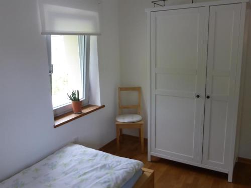 a bedroom with a bed and a window and a chair at Irreler Mühle Ferienwohnungen und Ferienhäuser in Irrel