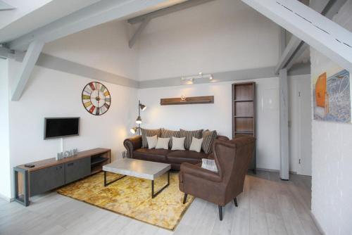 ein Wohnzimmer mit einem Sofa und einem TV in der Unterkunft Schiller-Quartier 15 in Bremerhaven