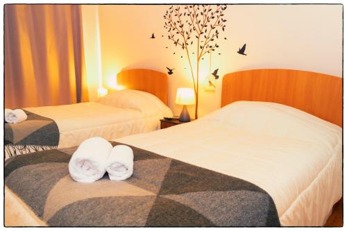 a hotel room with two beds and birds on the wall at Hostal Los Teros in Coihaique