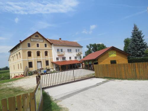 a building with a wooden fence and a house at Mill House Apartment and Camping in Ljutomer